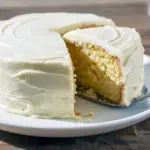 A golden, moist vanilla cake on a cooling rack, sliced to show its soft crumb — perfect for Cake Baking Recipes For Beginners and Simple Tasty Cake Recipes, ideal Birthday Cake Homemade Easy for any celebration.