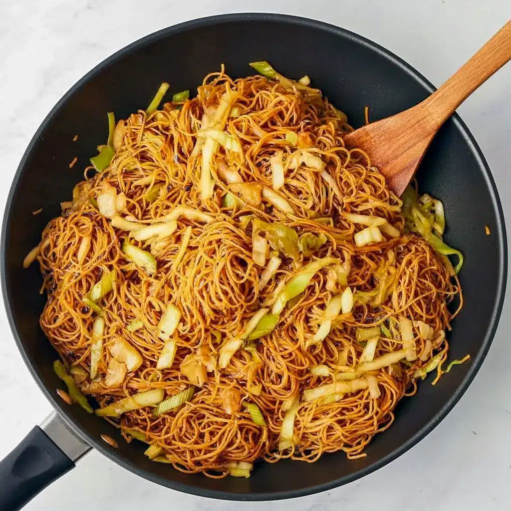 Close-up of Homemade Panda Express Chow Mein in a skillet: glossy chow mein noodles with shredded cabbage, sliced celery, and onions.