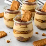 Layered jar of Easy Biscoff Tiramisu with coffee-soaked Biscoff cookies, mascarpone cream, and a dusting of cocoa.