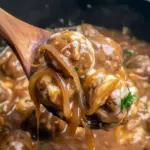 Crock Pot French Onion Meatballs topped with melted cheese in a slow cooker — perfect Crockpot Party Food Crowd Pleasers.