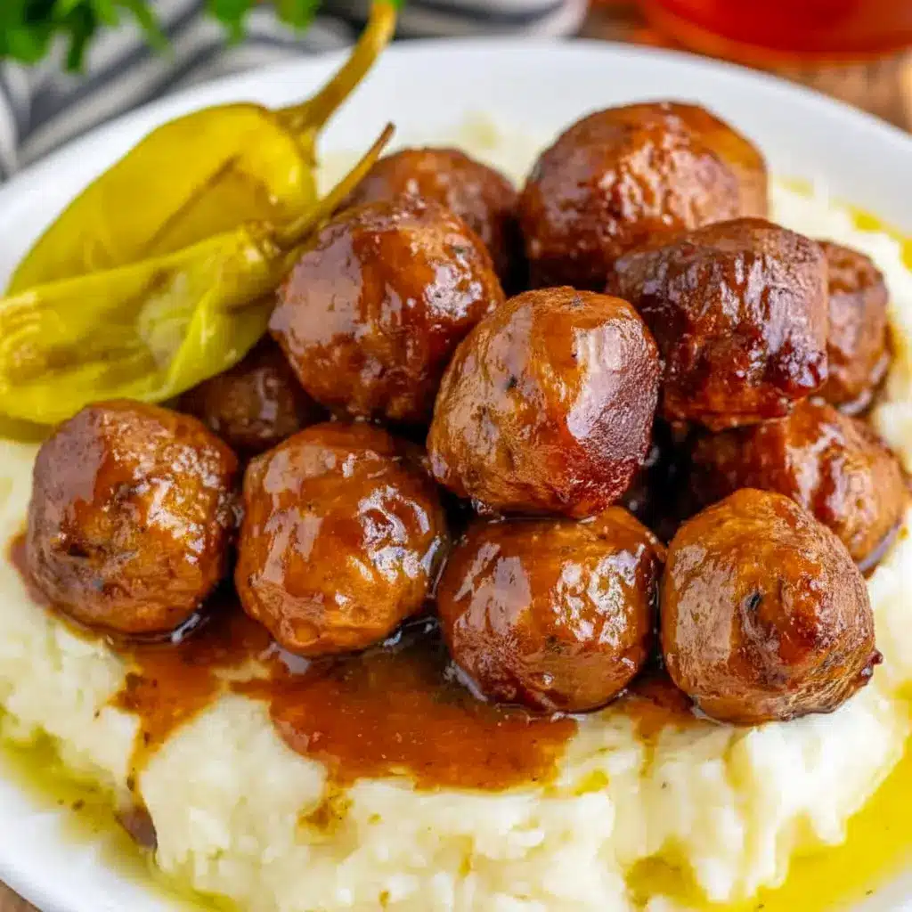 A serving of Crock Pot Mississippi Meatballs with glossy sauce and pepperoncini peppers, styled as Slow Cooker Mississippi Meatballs for an easy comfort food dinner.