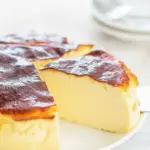 Slice of Creamy Yogurt Cake on a white plate, showing a smooth, custardy interior and a lightly caramelized top.