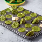 Blender Muffins made with spinach, banana, and oats, shown as mini green muffins on a breakfast plate for kids.