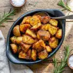 Golden Crispy Roast Potatoes piled on a tray, a delicious Crunchy Roasted Potatoes Recipe for dinner or holidays.
