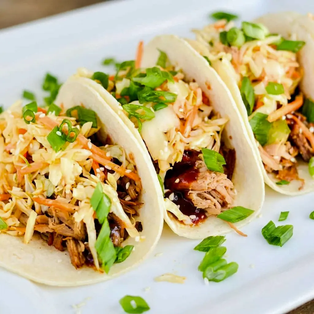 Korean BBQ Tacos filled with saucy shredded pork and cheese, a bold twist on Pulled Pork Korean Bbq Tacos.
