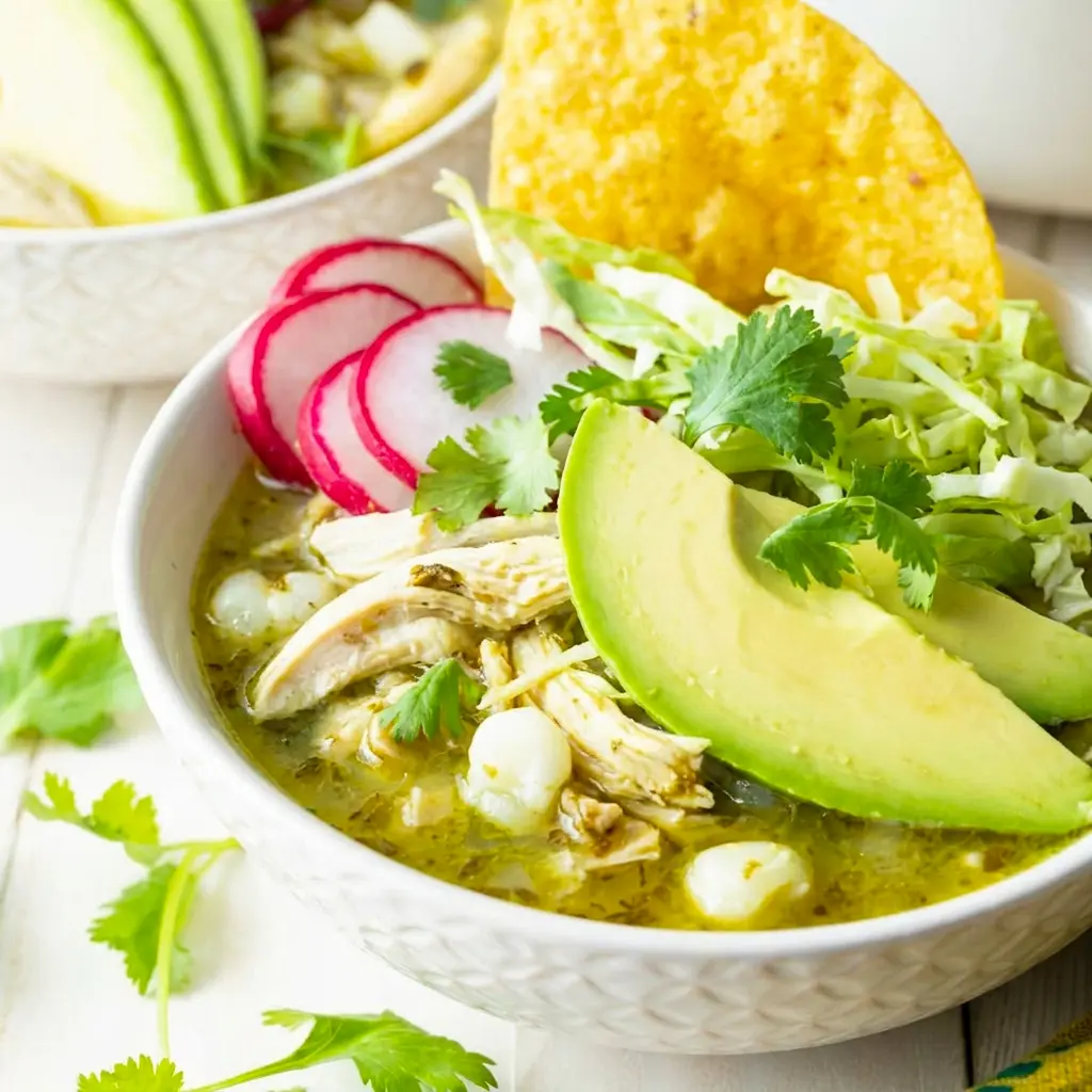 Pozole Verde de Pollo simmering in a rustic bowl, styled as a cozy Green Chili Chicken Pozole dinner with fresh lime and cilantro.