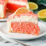 A slice of Hawaiian Guava Cake with glossy pink glaze and coconut cream cheese layers, styled as a tropical take on Brazil Cakes.