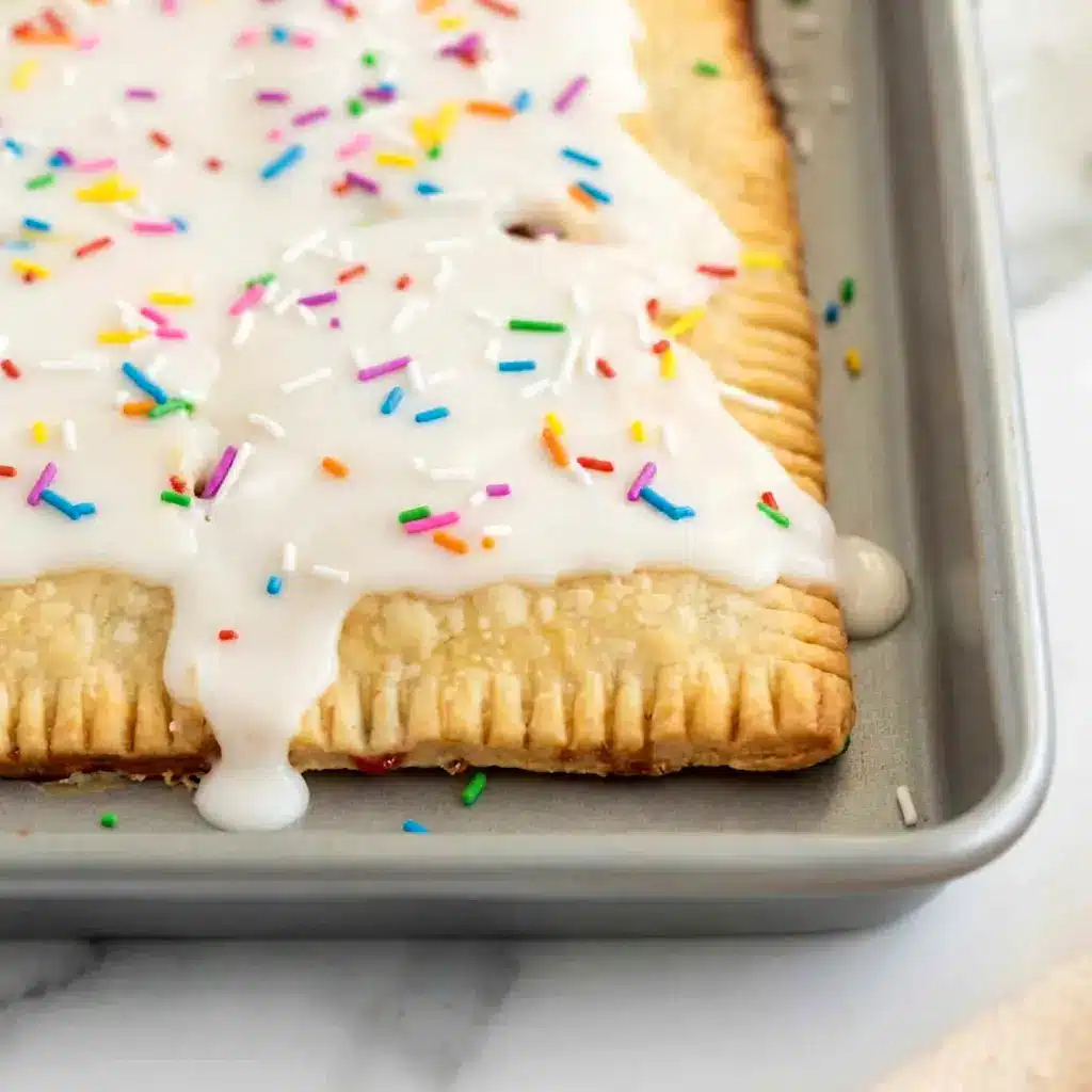 Strawberry Sheet Pan Pop Tart served warm and topped with colorful sprinkles, ideal for Brunch Snacks For A Crowd.