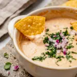 Cottage Cheese Queso Dip served as a creamy Macro Friendly Snack Recipes idea, topped with fresh cilantro and ready for tortilla chips.