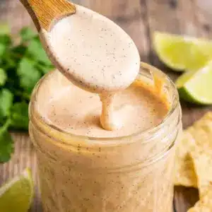 Taco Salad Dressing drizzled over a colorful taco bowl with fresh lettuce, tomatoes, cheese, and a creamy Homemade Taco Salad Dressing finish.