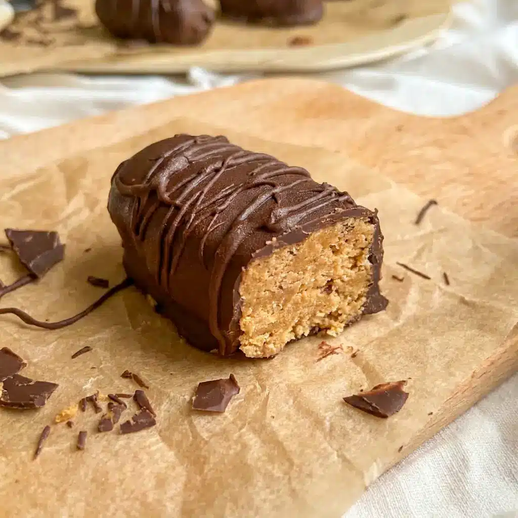Healthy Homemade Butterfingers stacked on parchment paper for Low Fat Healthy Desserts, with a crunchy chocolate coating and peanut butter center.