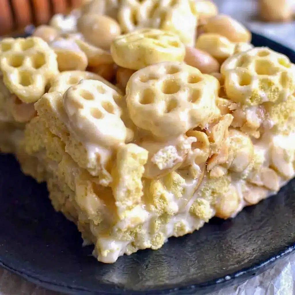 A single square of Honeycomb Marshmallow Treats held up close, made with real Honeycomb Cereal Treats flavor.