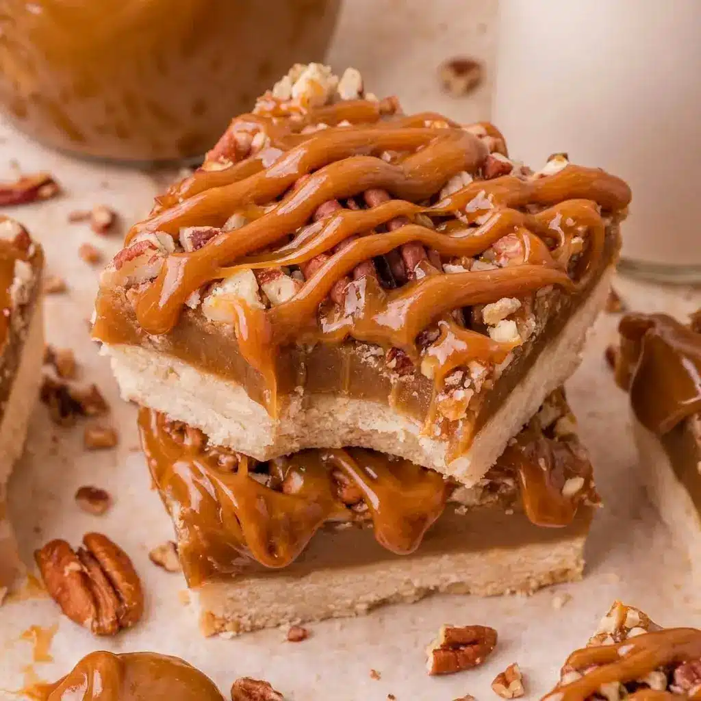 Side angle of stacked Salted Caramel Pecan Bars drizzled with extra caramel, an easy addition to any holiday spread of dessert bars.